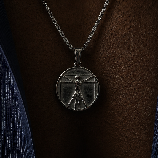 Silver necklace with a pendant with a design of Da Vinci worn by a black male model wearing a navy shirt